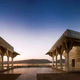 Ajmer Baradaris, 1636, Ana Sagar Lake: To fulfill a vow made as thanksgiving for a successful military campaign, Shah Jahan ordered the construction of a Jami (prayer hall) immediately behind Muin al-Din Chishti’s tomb. The white marble prayer hall has a 45-metre-long line of 11 arch-shaped openings, borne on slender pillars and sheltered by an angled chhajja (overhanging) below. The interiors are divided by slender pillars into 22 bays and have flat ceilings throughout, possibly to preempt architectural competition with the dome that rises above the saint’s mausoleum. The focal mihrab (niche) of the mosque has a part-octagonal recess with net vaulting above. Around 18 years later, Shah Jahan added an imposing arched gate that served as a monumental entrance to the dargah. Shah Jahan’s daughter Jahanara, another passionate disciple of the Ajmer saint, added the elegant marble entrance porch. Among Shah Jahan’s other contributions to Ajmer is a series of baradaris built beside Ana Sagar, the great artificial lake on the outskirts of the city. These pavilions occupy the site of a garden residence laid out by Jahangir. Shah Jahan’s white marble baradaris have pillared verandas sheltered by angled chhajjas. The verandas lead to flat-ceilinged rectangular chambers, one of which has a balcony looking out over the lake.